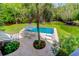 Aerial view of a backyard pool with lounge chairs, table, umbrella, and lush landscaping at 932 Middle St, Sullivans Island, SC 29482