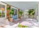 Inviting front porch featuring wood-paneled ceilings, blue French doors, and lush tropical plants, enhancing curb appeal at 932 Middle St, Sullivans Island, SC 29482