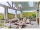 Relaxing covered porch with comfortable seating and views of the surrounding trees at 932 Middle St, Sullivans Island, SC 29482
