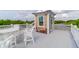 Enjoy outdoor dining and relaxing on this rooftop deck with white patio furniture and neighborhood views at 932 Middle St, Sullivans Island, SC 29482