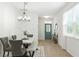 Elegant dining room with modern decor, wood-look floors, and a view of the front entrance at 9815 Seed St, Ladson, SC 29456