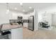 Bright kitchen with stainless appliances, white cabinets, and a view into the dining area at 9815 Seed St, Ladson, SC 29456
