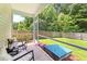 View of covered patio leading to a well-maintained lawn and fenced-in backyard with green foliage at 9815 Seed St, Ladson, SC 29456