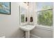 Well-lit powder room features a pedestal sink and a mirror, creating a clean and inviting space at 992 Key Colony Ct, Mount Pleasant, SC 29464