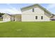 Back yard view of white home, showing a detached garage and modern covered porch at 104 Brightwood Dr, Huger, SC 29450