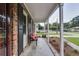 Covered front porch provides an airy view, featuring a comfortable bench and beautifully landscaped surroundings at 104 Jackson Rd, Ladson, SC 29456
