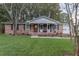 Charming brick home featuring a well-manicured lawn, covered porch, and updated front door at 104 Jackson Rd, Ladson, SC 29456