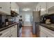 Galley kitchen featuring stainless steel appliances, white cabinetry, and black countertops, creating a sleek, modern look at 104 Jackson Rd, Ladson, SC 29456