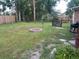 Large grassy backyard featuring a round brick fire pit and perimeter fence at 106 Labrador Ct, Summerville, SC 29485