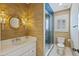Cozy bathroom featuring textured walls, custom vanity, rattan mirror, and glass-enclosed shower at 1075 Wayfarer Ln, Charleston, SC 29412