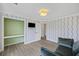 Well-lit bedroom with a small green couch, a built in closet, and light hardwood flooring at 1075 Wayfarer Ln, Charleston, SC 29412