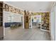 Open-concept living room with decorative wallpaper, hardwood floors, and seamless flow to the kitchen and additional living space at 1075 Wayfarer Ln, Charleston, SC 29412