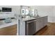 Kitchen island features stainless steel dishwasher, gray cabinets, granite countertops, and an open view to the living space at 113 Moscato Ln, Summerville, SC 29485