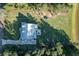 Aerial view of backyard with trampoline and large lawn surrounded by green trees and neighborhood pond at 1130 Plantation Overlook Dr, Moncks Corner, SC 29461
