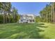 Spacious home exterior with a screened porch, large yard and view of surrounding trees offering privacy at 1130 Plantation Overlook Dr, Moncks Corner, SC 29461