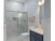 Elegant bathroom with a glass-enclosed shower, blue vanity, and marble tile flooring at 1130 Plantation Overlook Dr, Moncks Corner, SC 29461