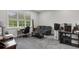 Spacious bedroom includes neutral-colored walls, carpeted floors, a window view, and a seating area with a dark gray sofa at 1130 Plantation Overlook Dr, Moncks Corner, SC 29461