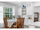 Bright dining area with hardwood floors, a table set for eight, white cabinets, and a backyard view at 1130 Plantation Overlook Dr, Moncks Corner, SC 29461