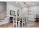 Dining room with a wooden table, white chairs, a modern chandelier, and view to stairs at 1130 Plantation Overlook Dr, Moncks Corner, SC 29461