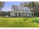 Stunning two-story home with a sprawling porch, lush lawn, and mature trees, offering curb appeal and outdoor space at 1130 Plantation Overlook Dr, Moncks Corner, SC 29461