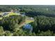 Aerial view of a light blue two-story home surrounded by lush, green trees and tranquil pond at 1130 Plantation Overlook Dr, Moncks Corner, SC 29461