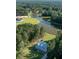 Aerial view of a light blue two-story home surrounded by lush, green trees and tranquil pond at 1130 Plantation Overlook Dr, Moncks Corner, SC 29461