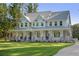 Stately two-story home boasts a welcoming wraparound porch and a lush, green lawn at 1130 Plantation Overlook Dr, Moncks Corner, SC 29461