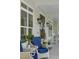 Inviting front porch with white wicker chairs, blue cushions, and elegant floral wreaths on the front door at 1130 Plantation Overlook Dr, Moncks Corner, SC 29461