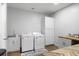 Well-equipped laundry room with washer, dryer, sink, cabinets, and wood-look flooring at 1130 Plantation Overlook Dr, Moncks Corner, SC 29461