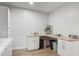 Bright laundry room featuring white cabinets, herringbone countertops, and modern decor at 1130 Plantation Overlook Dr, Moncks Corner, SC 29461