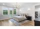 Bright main bedroom features hardwood floors, a tufted bed, and french door access to balcony at 1130 Plantation Overlook Dr, Moncks Corner, SC 29461