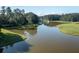 Aerial view of a tranquil pond with fountain feature surrounded by lush, green trees at 1130 Plantation Overlook Dr, Moncks Corner, SC 29461