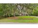 Charming home with lush landscaping, a well-manicured lawn and mature trees with Spanish Moss at 1225 Dennis Blvd, Moncks Corner, SC 29461