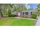 Charming brick home with a well-maintained lawn and mature trees draped in Spanish moss at 1225 Dennis Blvd, Moncks Corner, SC 29461