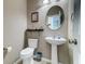 Stylish powder room featuring a pedestal sink, round mirror, and tasteful decor at 143 Dorothy Dr, Charleston, SC 29414