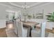 Bright dining room featuring modern chandelier, light wood table, and white cushioned chairs, perfect for Gathering dinners at 1436 Lagoon Park Cir, Mount Pleasant, SC 29466