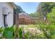 A backyard with a brick house in the background, surrounded by a wood fence, foliage, and a firewood storage shed at 1468 N Relyea Ave, Charleston, SC 29412