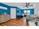 Blue bedroom with hardwood floors, ceiling fan, and two twin beds under large windows at 1468 N Relyea Ave, Charleston, SC 29412