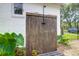An outdoor shower features a wood surround and a black shower head in a well landscaped backyard at 1468 N Relyea Ave, Charleston, SC 29412