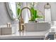 Close-up of a modern bathroom with a vessel sink, brass faucet, and decorative orchids at 149 Cooper River Dr, Mount Pleasant, SC 29464