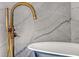 Elegant gold faucet with handheld sprayer above a freestanding tub against marble tile at 149 Cooper River Dr, Mount Pleasant, SC 29464