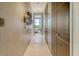 Inviting hallway with white tiled floor and neutral wall color, featuring a decorative wall hanging and doors to bedrooms at 149 Cooper River Dr, Mount Pleasant, SC 29464