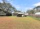 View of home showing the backyard and outbuildings. Mature trees provide ample shade at 1613 Cavanaugh Rd, Walterboro, SC 29488