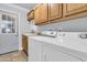 Functional laundry room featuring wood cabinets, a utility sink, and modern washer and dryer appliances for convenience at 1613 Cavanaugh Rd, Walterboro, SC 29488