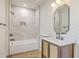 Modern bathroom with stylish vanity, neutral-tiled walls, and combined bathtub and shower at 1685 Old Military Rd, Charleston, SC 29412