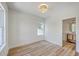 Serene bedroom with hardwood floors, a light fixture, two windows, and an attached bathroom at 1685 Old Military Rd, Charleston, SC 29412