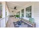 Spacious covered porch with seating, bench, and a ceiling fan, perfect for outdoor entertainment and relaxation at 1685 Old Military Rd, Charleston, SC 29412