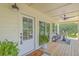 Inviting front porch with a seating area, ceiling fan, and views of the landscaped front yard at 1685 Old Military Rd, Charleston, SC 29412