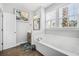 Bright bathroom featuring double sinks, tile flooring, and a large soaking tub at 183 Calm Water Way, Summerville, SC 29486