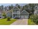 Charming two-story home with a double porch, green lawn, and two-car garage at 183 Calm Water Way, Summerville, SC 29486